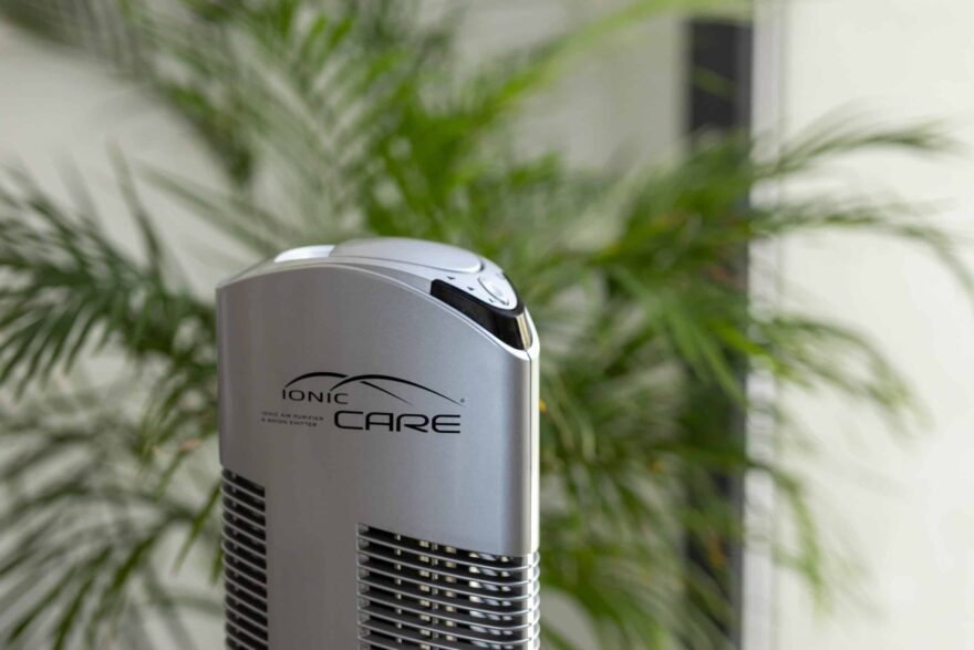 Detail oczyszczacze powietrza Ionic-CARE ve stříbrné barvě, v pozadí se zelenou rostlinou